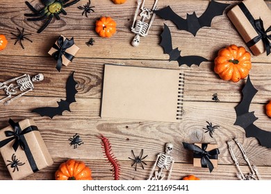 Open empty notebook surrounded by Halloween decorations on a wooden table. Top view rustic background with copy space. - Shutterstock ID 2211695441