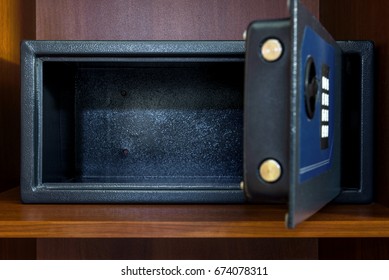 The Open Empty Safe In Hotel Room Or House. Safety Box, Modern Electronic Locker At Home. Small Dark Safe On Closet Shelf In Interior. Concept Of Safe, Deposit, Robbery And Theft.