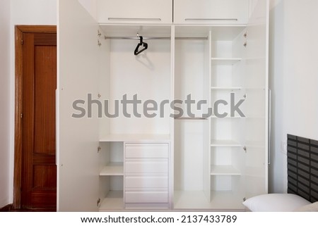 Open empty white closet layout with shelves, drawers and hanger rods