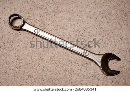 Open end spanner and ring spanner combination on a concrete ground.