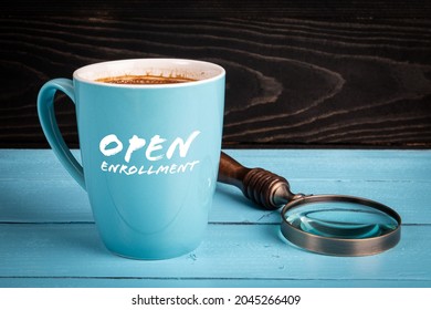 Open Enrollment. Coffee mug with text on a wooden table.
