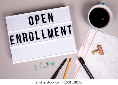 Open Enrollment concept. White lightbox on a gray office desk