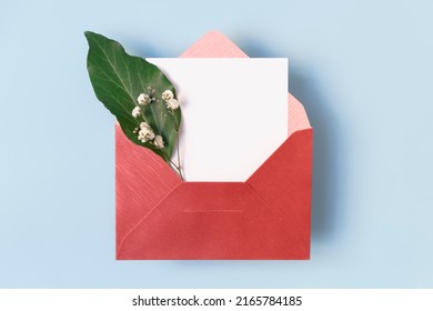 Open Envelope With Flowers And White Blank Card On Light Blue Background, Copy Space, Top View