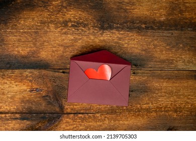 Open envelope with red hearts. Dark wooden background. Love correspondence concept. Love letter for valentine's day.