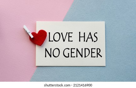 An open envelope with the text LOVE HAS NO GENDER, on a pink and blue background with a decor of felt hearts and a flower. Flat lay, top view. LGBT concept.