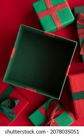 Open Festive Christmas Present Box On A Red Background. Flat Lay, Top View