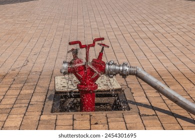 Open fire hydrant with a connected hose and splashing water.Water in motion.Blur