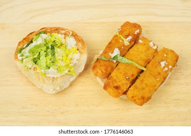 Open Fish Finger Roll With Lettuce And Tartar Sauce On A Wooden Board