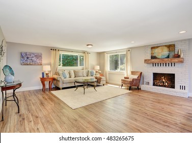 Open Floor Plan Living Room Interior In White Tones With Hardwood Floor. Also White Brick Fireplace. Northwest, USA