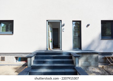 Open Front Door In A New Building With Stairs In Front Of It