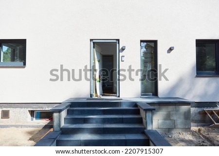 Open front door in a new building with stairs in front of it