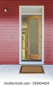 Open front door of new home with plan mat
