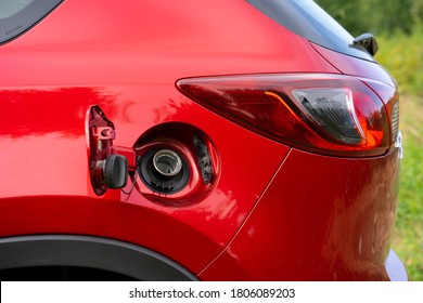 An Open Fuel Tank Cap Of A Red Car For Filling Gasoline Or Diesel Fuel Into The Gas Tank. The Back Of The Car With An Open Gas Tank.