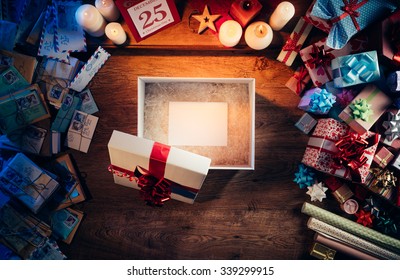 Open Gift Box With A Blank White Card Inside, Presents And Christmas Letters All Around, Desktop Top View
