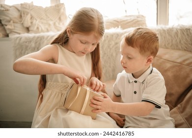 Open gift. Surprise in kids hands at home. Happy and funny boy and girl open birthday present box. Cheerful childs with surprise. Happy childhood. National Children's Day. Friends. Brother and sister.