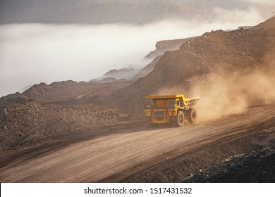 Open Gold Pit Mine Industry. Big Yellow Mining Truck For Gold Moving On Road Career.