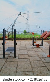 An Open Gymnasium In The Park Near The River With Fishing Nets In The Background