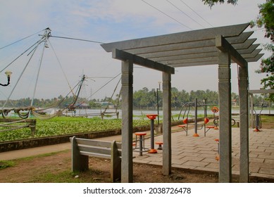 An Open Gymnasium In The Park Near The River With Fishing Nets In The Background