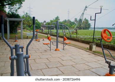 An Open Gymnasium In The Park Near The River With Fishing Nets In The Background