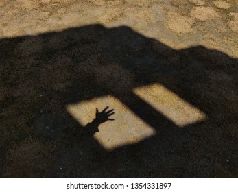 Open hand in window shadow.