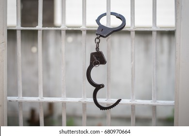 Open handcuffs hang on the cage. Successful escape exemption - Shutterstock ID 680970664