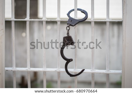 Open handcuffs hang on the cage. Successful escape exemption
