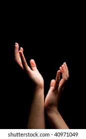 Open hands trying to catch something in the darkness