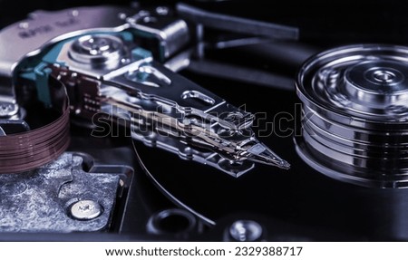 Open hard disk drive with magnetic head closeup.
