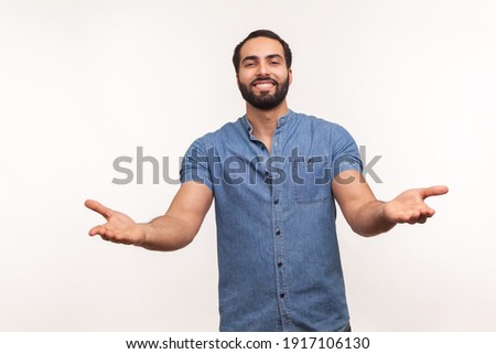 Open hearted generous man with beard sharing opening hands looking at camera with kind smile, greeting and regaling, happy glad to see you. Indoor studio shot isolated on white background