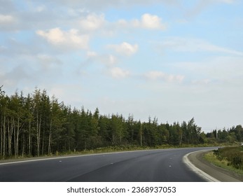 An open highway with a sharp corner extending along it.