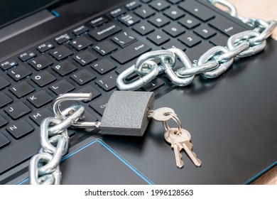 open hinged iron lock with keys and an iron chain on the laptop keyboard concept information protection internet censorship. High quality photo