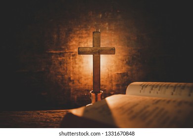 Open Holy Bible and candle on a old oak wooden table. Beautiful gold background. Religion concept.  - Shutterstock ID 1331670848