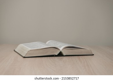 Open holy bible on a  wooden table. Beautiful white wall background. - Shutterstock ID 2153852717