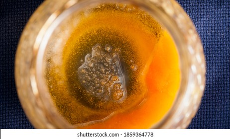 Open Honey Jar Almost Empty On Blue Tablecloth