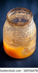 Open Honey Jar Almost Empty On Blue Tablecloth