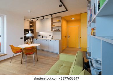 Open interior of kitchen with dining table in small urban apartment