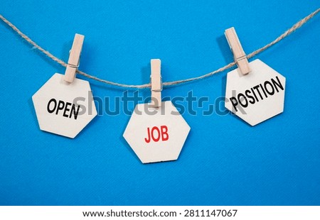 Open Job Position text on wooden hexagon tags hanging on rope with clothespins over blue background. Employment opportunity and recruitment concept with copy space.