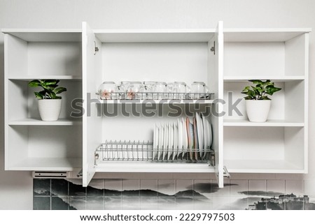 open kitchen cabinet with plates dishes glasses