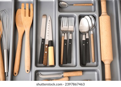 Open kitchen drawer with different silver cutlery