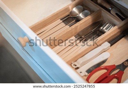 Open kitchen drawer with silverware , Kitchenware and dining accessories in drawer