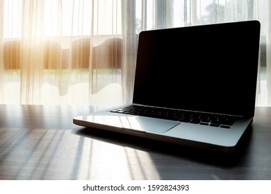 An Open Laptop With Black Screen Monitor On Wooden Table In Office. A Laptop Is A Computer Which Is Easy To Carry Around.