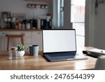 Open laptop with blank screen on a wooden desk in a kitchen room home office
