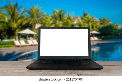 Open Laptop With Blank Screen On Wooden Table And Hotel Or Resort Pool Blurred Background, Remote Or Distant Work Place, Travel Or Vacation Working Concept