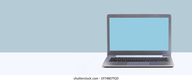 Open Laptop. Blue Mockup Screen On White Desk And Plain Background Banner. Distant Learning. Working From Home, Online Courses Or Support Minimal Concept. Helpdesk Or Call Center Copy Space