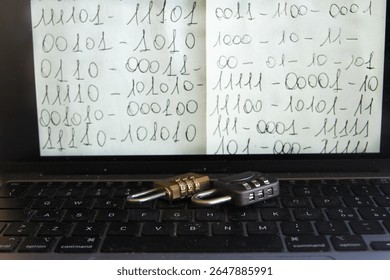 open laptop displaying handwritten binary code on screen with two combination padlocks on the keyboard, symbolizing digital data protection