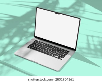 Open laptop with empty white display on a pastel mint surface, palm leaf shadows softening the minimalist composition for a clean product mockup.