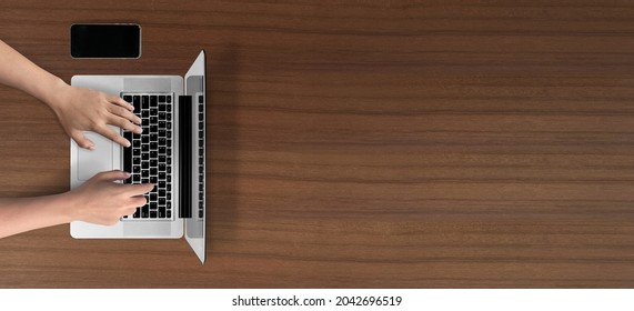 Open laptop with hands typing on keyboard isolated on wooden table background. of free space for your copy, view from top. - Shutterstock ID 2042696519