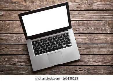 Open laptop with isolated screen on old wooden desk.