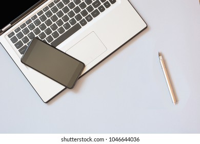 Open laptop and mobile on blue background. Business concept. Top view. Copy space.