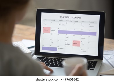 Open Laptop On The Desk With A Planner Calendar On The Screen. Education Concept Photo, View Over The Shoulder, Close Up